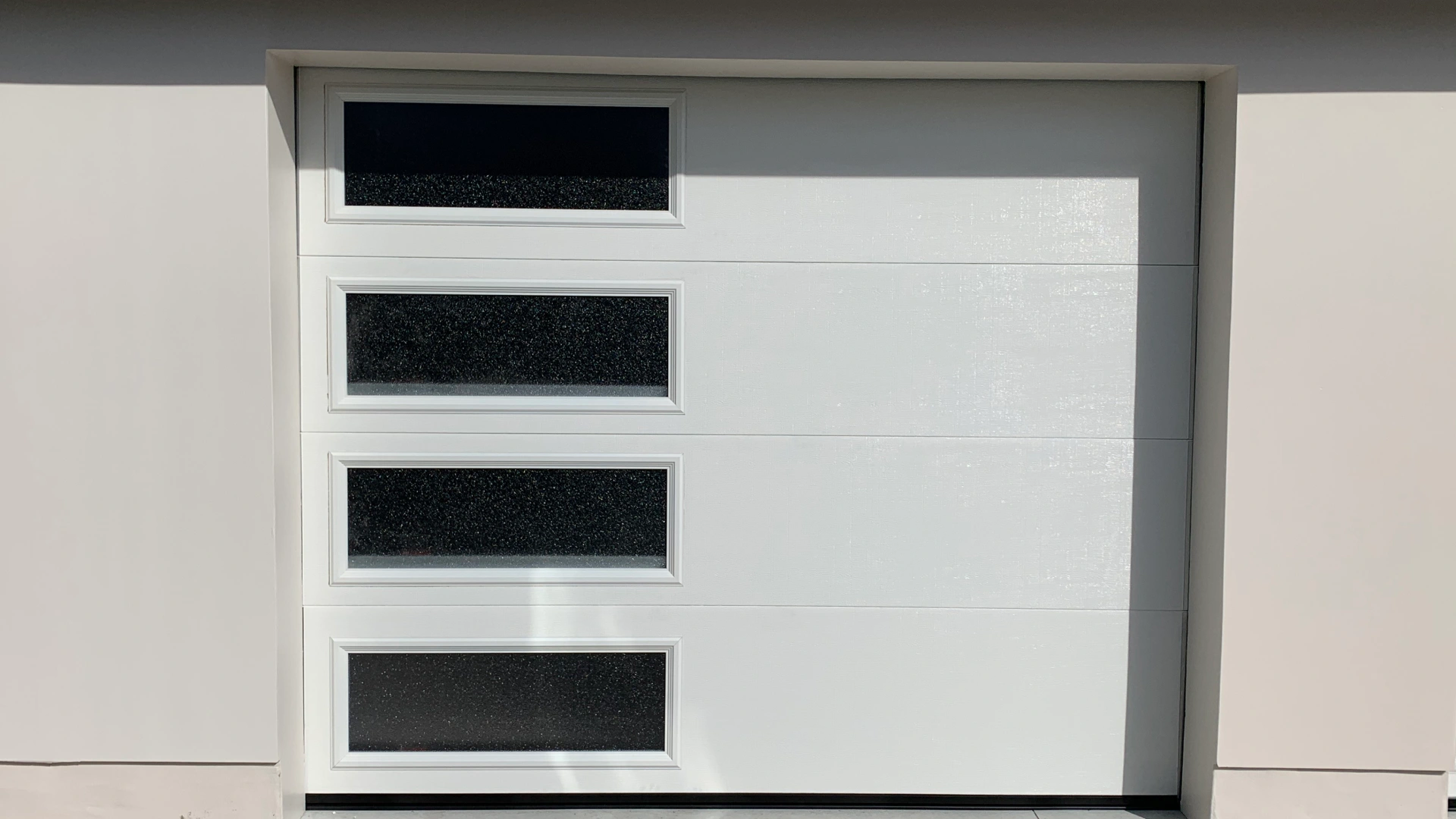 a modern garage door with minimalist design and glass peeking